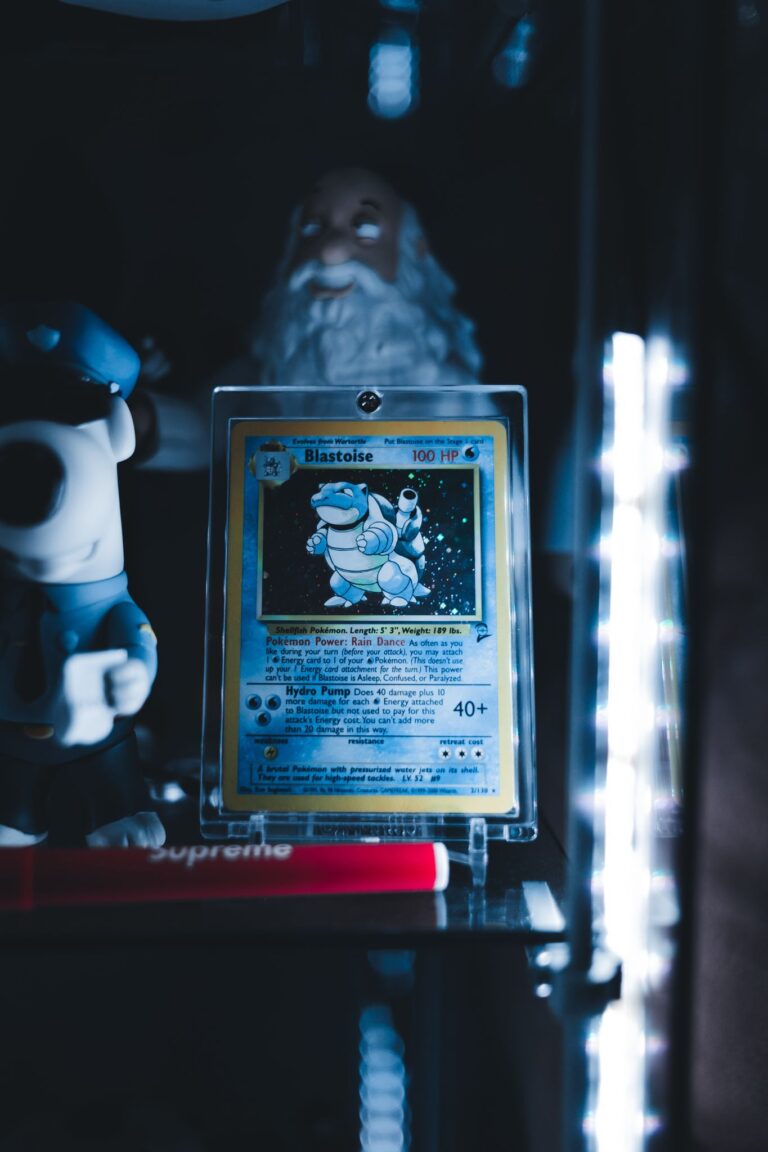 Blastoise Pokémon card in a protective case on display shelf with collectibles and ambient lighting.