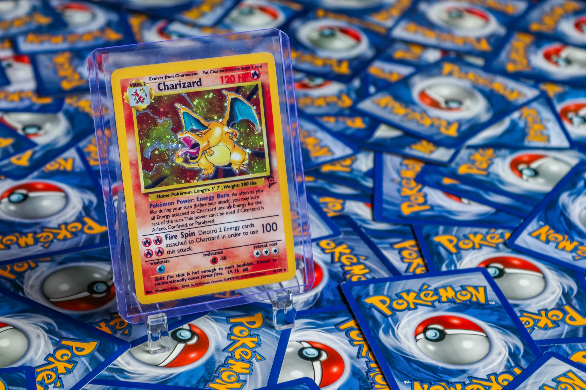 High-value Charizard Pokémon trading card surrounded by various other cards.